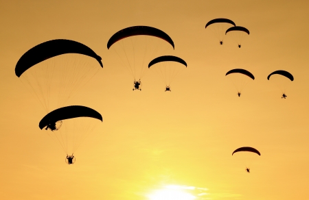 Group of paragliding on the sunset background, Black shadow. の写真素材