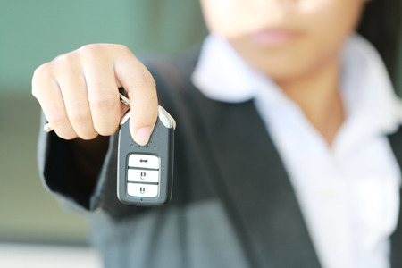 Business woman show a remote key for operate car.の写真素材