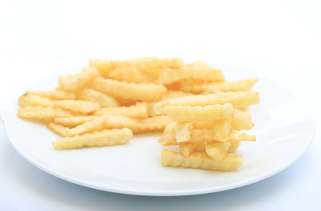 Close up French fries potatoes stack on white dish background.の写真素材