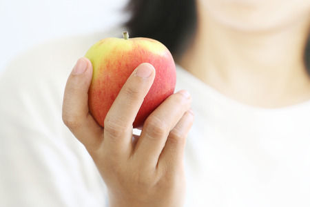 Woman hand holding red apple, close up.の写真素材