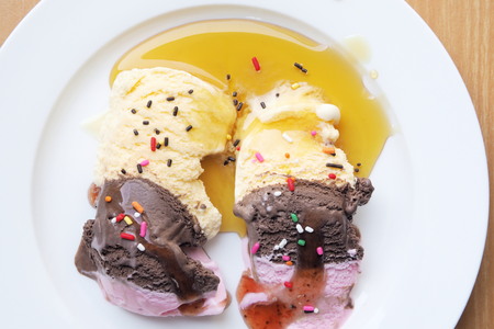 ice cream in white dish with sprinkles and caramel.