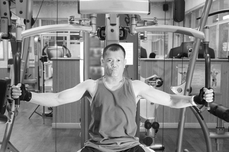 Exercising in the gym, Strong man lifting hand weights.Black and white.