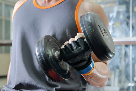 Muscular man working out with dumbbellsの写真素材