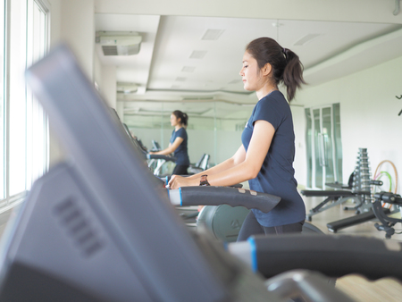 Asian woman walking,  running on treadmill gym workout.の写真素材