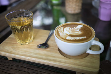 Hot coffee in white cup, served with teaの写真素材