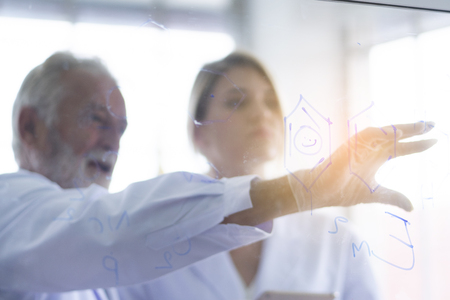 Male and female scientists are discussing details for testing and analysis to find the results of medical research. Scientific and chemical conceptsの写真素材