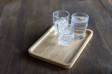 Glass of cold water placed on a wooden tableの写真素材