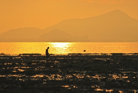 fisherman on the beach at sunriseの写真素材