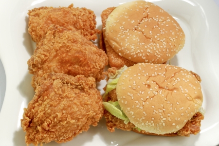 Chicken and hamburgers on white dishの写真素材