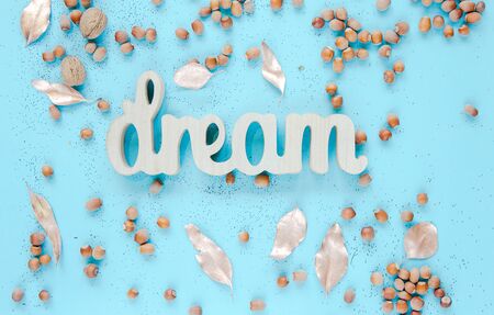 Inspirational quote Dream Wood letters with nature decor,flowers and acorns on blue backgrond. Flat lay, top view.の写真素材