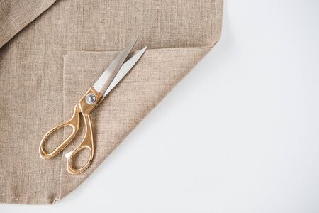 Organic eco shopping bag with tailor scissors with gold handle isolated on white background, top view. Design mockup.の写真素材