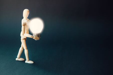 Wooden puppet with light bulb.Business Creative and Idea Concept.Idea and inspiration concept....
