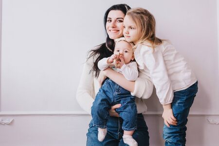 Mother and child . Mom and baby girl playing in sunny room. Mother and child girl playing, kissing and hugging.の写真素材