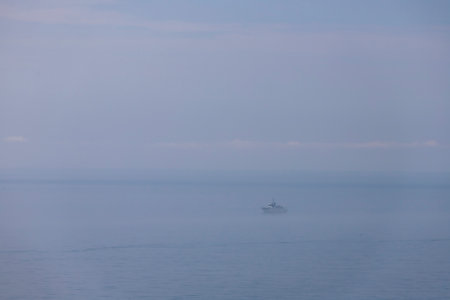 Fishing boat on the sea in a foggy morning. Selective focus.
