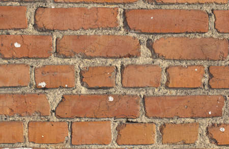 Dilapidated brick wall with remnants of plaster