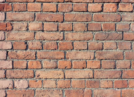 Dilapidated brick wall with remnants of plaster