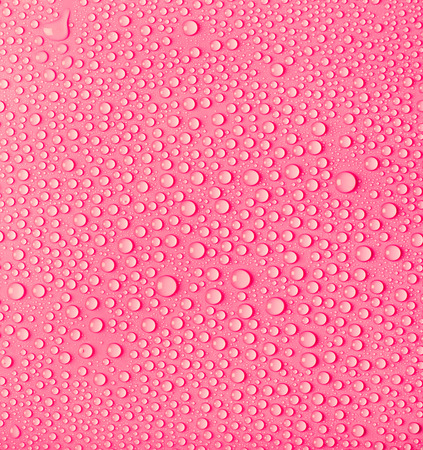 Transparent pure water droplets on a pink background. Drops of water close-up.の写真素材