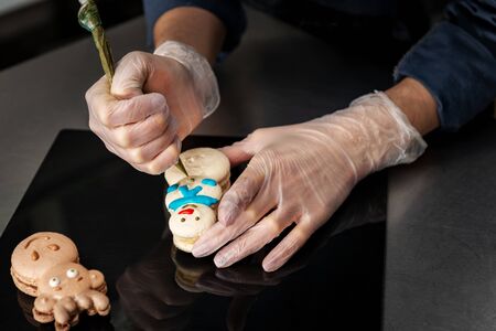 Confectioner makes a cake in the form of figures of Christmas heroes. Handwork