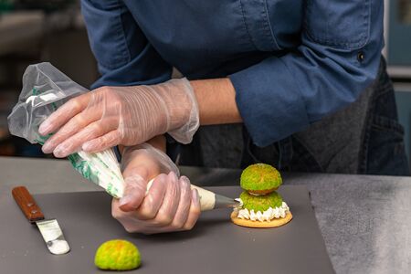 Confectioner makes a cake in the form of figures of Christmas heroesの写真素材