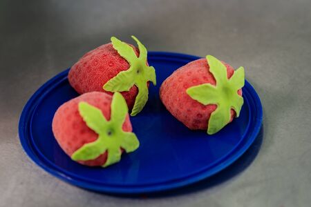 Confectioner makes bright colorful cakes in the shape of fruits and berriesの写真素材