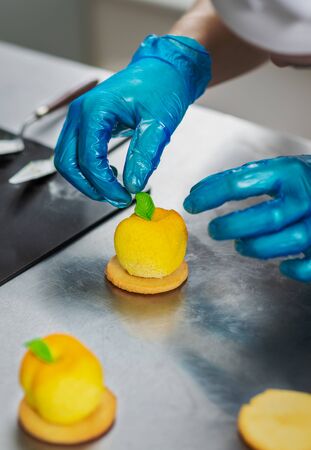 Confectioner makes a cake in the shape of fruits and berriesの写真素材