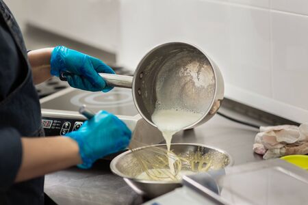 Gloved hands of confectioner make chocolate candiesの写真素材