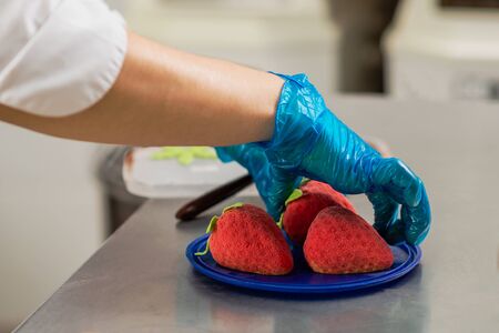 Confectioner makes bright colorful cakes in the shape of fruits and berriesの写真素材