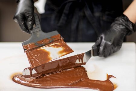 Confectioner in gloves makes chocolates in formsの写真素材