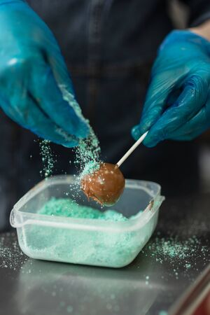 Gloved hands of confectioner make chocolate candiesの写真素材