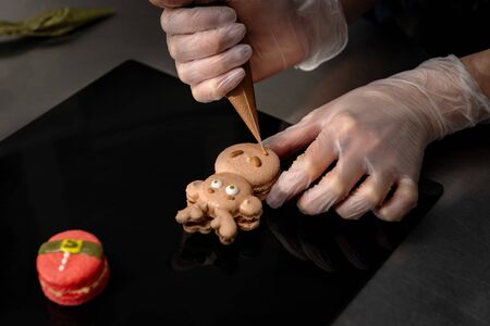 Confectioner makes a cake in the form of figures of Christmas heroes. Handworkの写真素材