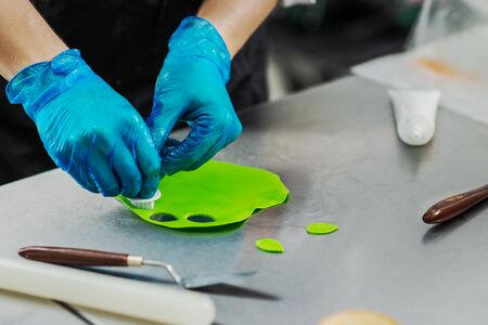 Confectioner makes bright colorful cakes in the shape of fruits and berriesの写真素材