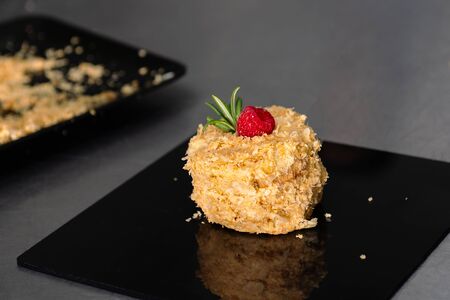 Confectioner in gloves makes a cake with cream and raspberries, sprinkled with crumbsの写真素材