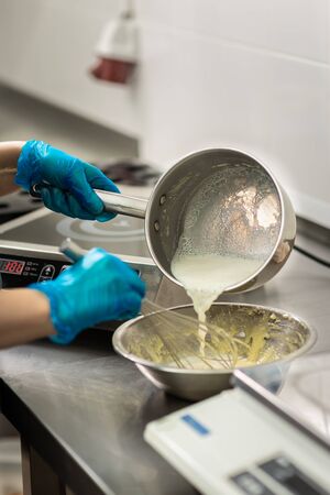 Gloved hands of confectioner make chocolate candiesの写真素材