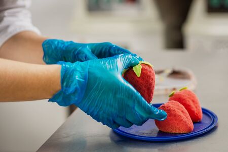 Confectioner makes bright colorful cakes in the shape of fruits and berriesの写真素材