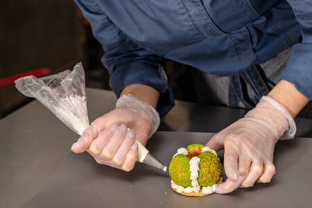 Confectioner makes a cake in the form of figures of Christmas heroesの写真素材