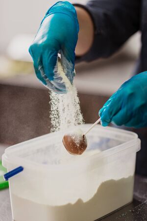 Confectioner in gloves makes chocolates in formsの写真素材