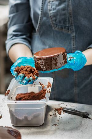Confectioner makes chocolate cake with icing and creamの写真素材