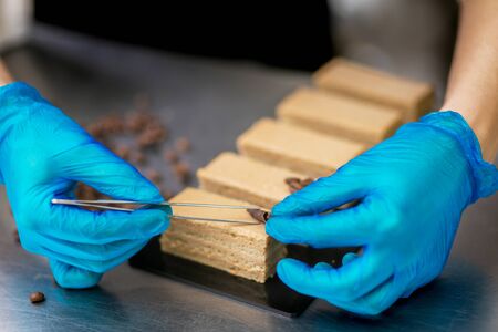 Confectioner makes a chocolate cake decorated with coffee grainsの写真素材