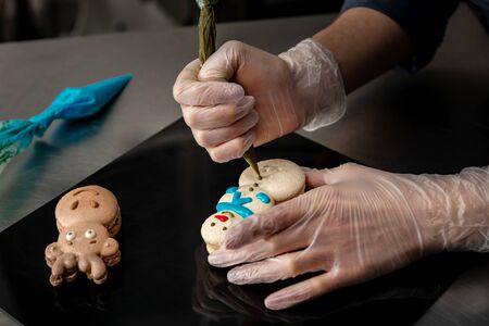 Confectioner makes a cake in the form of figures of Christmas heroesの写真素材