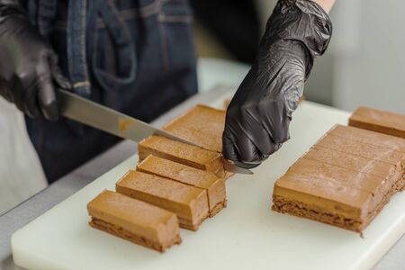 Confectioner makes a chocolate cake decorated with coffee grainsの写真素材