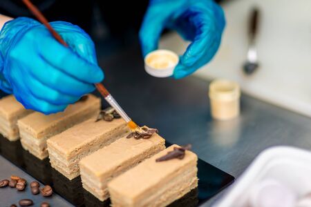 Confectioner makes a chocolate cake decorated with coffee grainsの写真素材