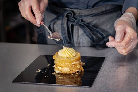 Confectioner makes a cake with cream and raspberries.の写真素材