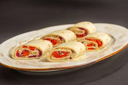 Rolls with fish with greens on a plate on a wooden backgroundの写真素材