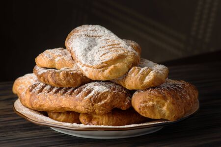 Appetizing buns with sugar parcel on a wooden backgroundの写真素材