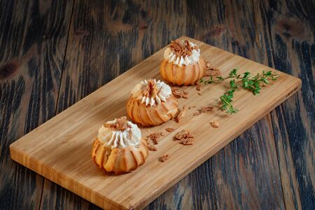 Profiteroles with vegetable filling, tomatoes and herbs on a wooden backgroundの写真素材