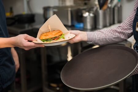 The chef passes the order to the waiterの写真素材