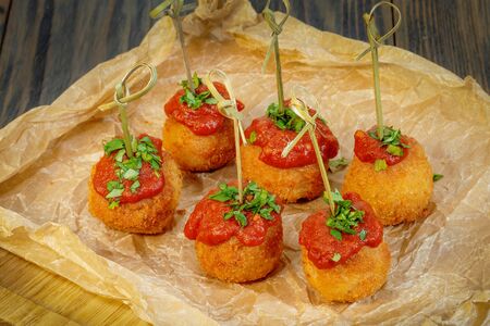 Rice balls with tomato sauce on paper. A wooden backgroundの写真素材