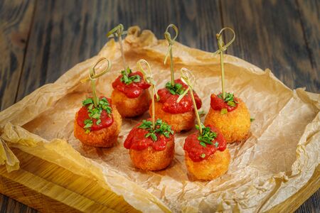 Rice balls with tomato sauce on paper. A wooden backgroundの写真素材