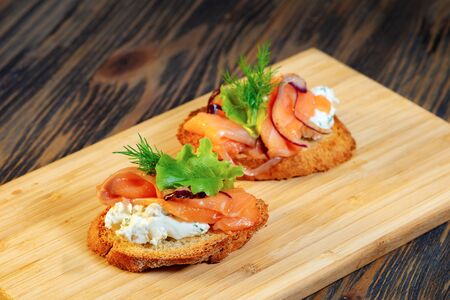 Fish and greens sandwich on a wooden cutting boardの写真素材