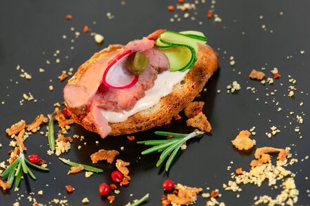 Tasty sandwiches with ham, cucumber, seasonings on a gray table, close upの写真素材